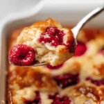 Close-up spoonful of fluffy pancake with raspberry on top